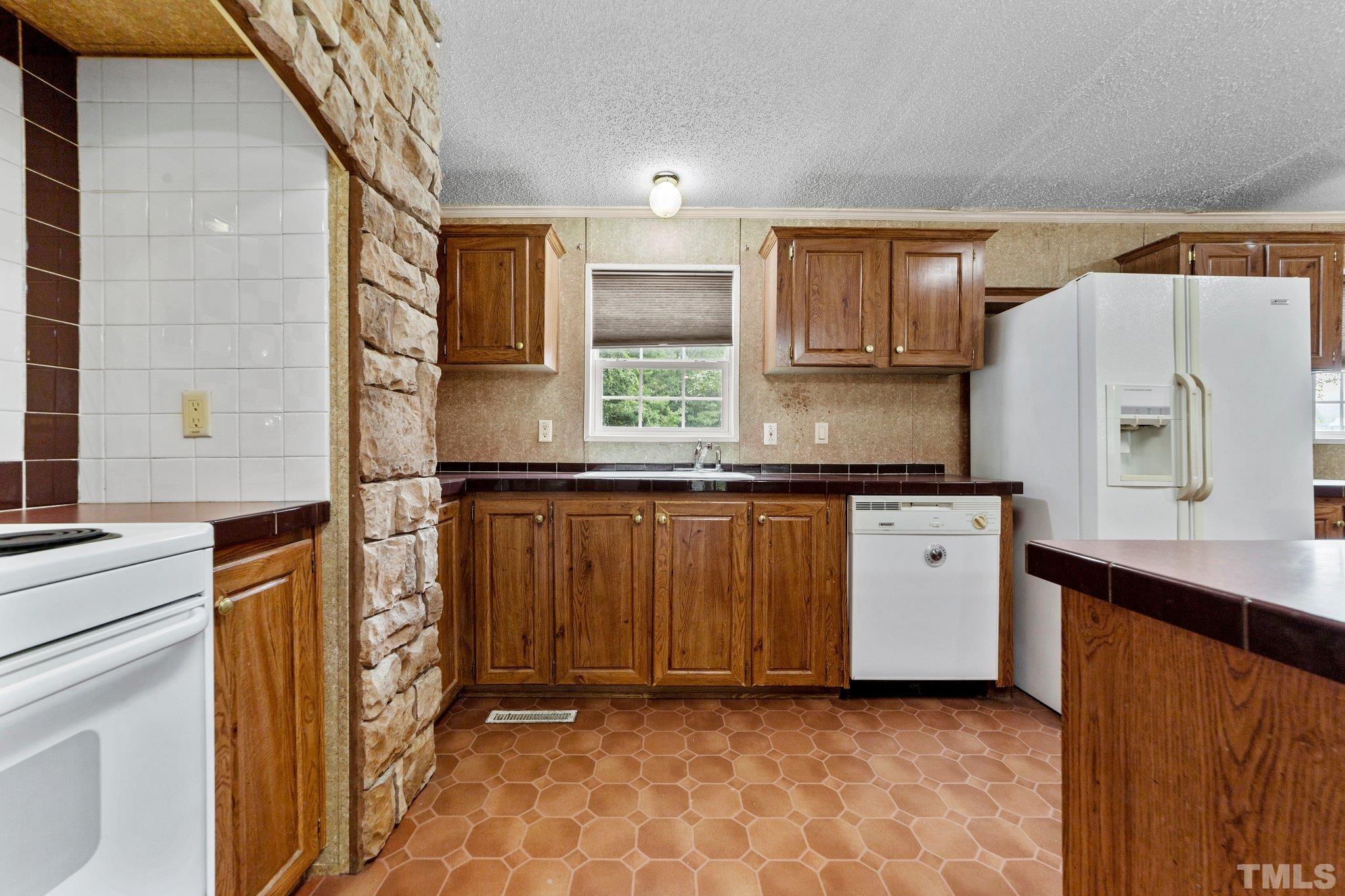 9617 Jernigan Road Spring Hope, NC 27882 - Photo 37 of 41 a kitchen with granite countertop a refrigerator and a stove