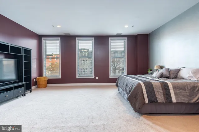 a spacious bedroom with a bed and a flat screen television