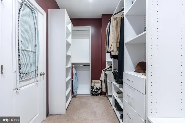 a view of walk in closet with clothes and shoes
