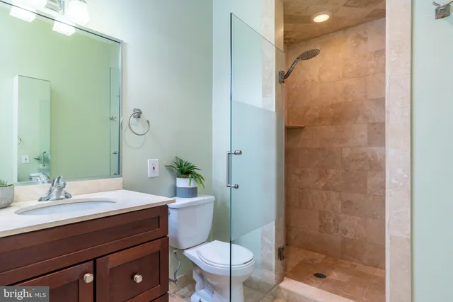 a bathroom with a sink a toilet a mirror and shower