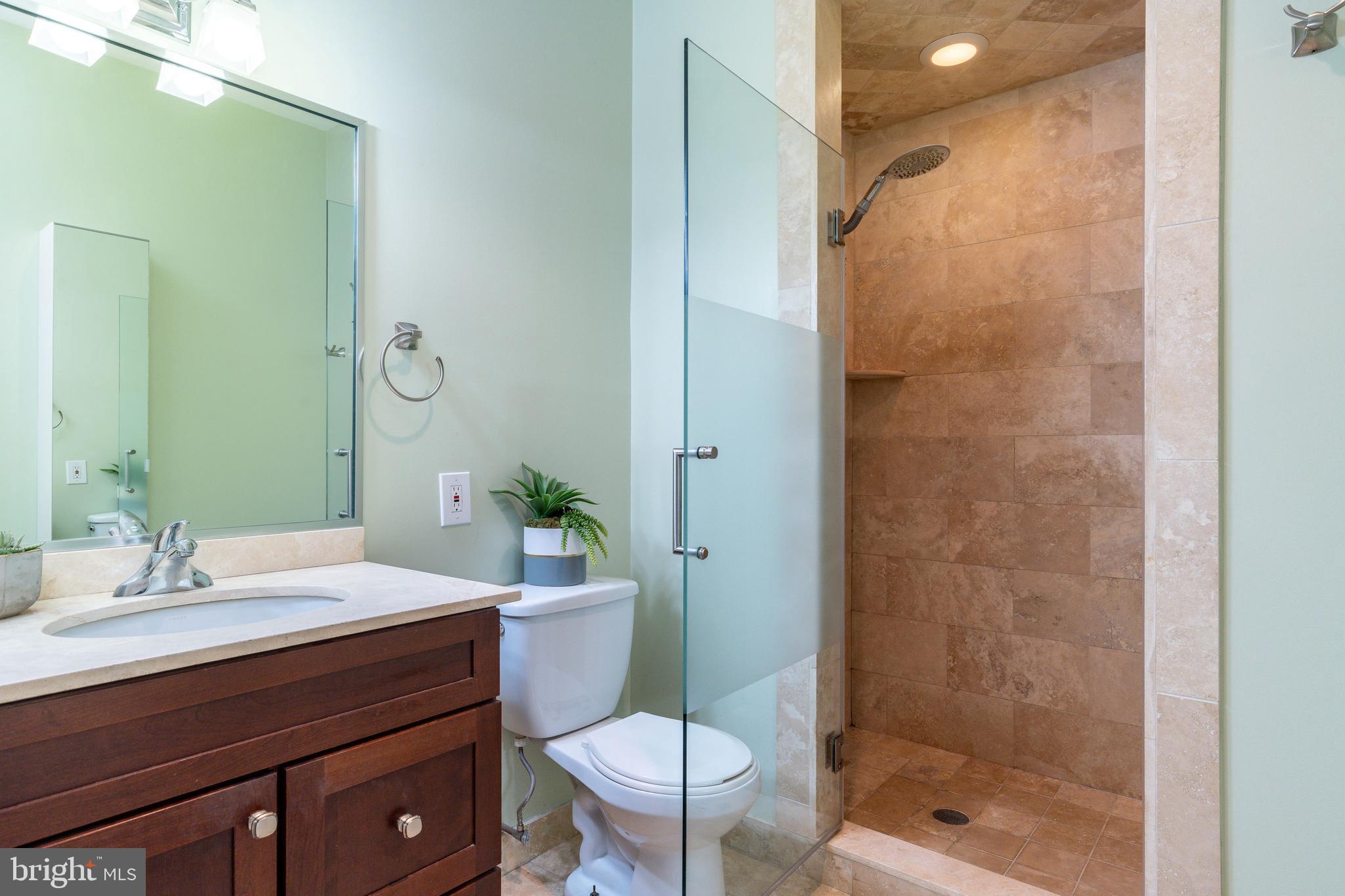 1910 Spring Garden Street, Unit 1 Philadelphia, PA 19130 - Photo 22 of 39 a bathroom with a sink a toilet a mirror and shower