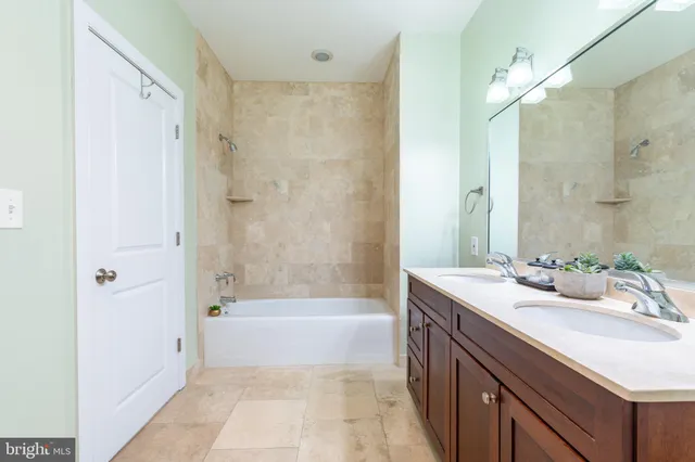 a bath room with a sink tub vanity and a shower