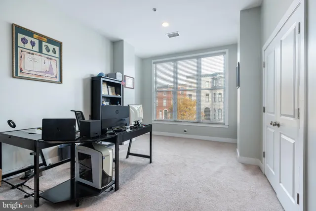 a view of a workspace with furniture and a window