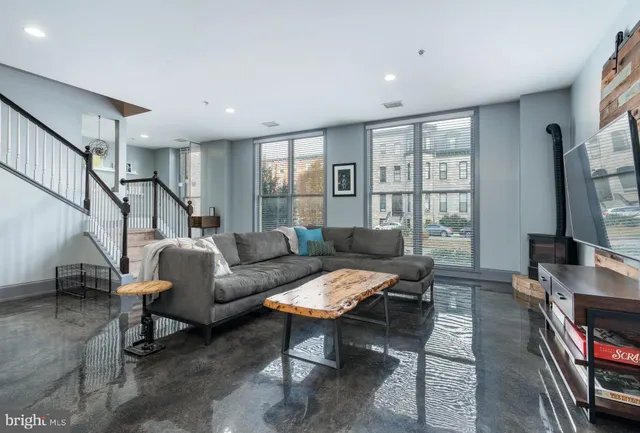 a living room with furniture a flat screen tv and a window