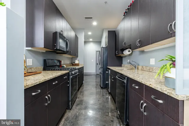 a kitchen with stainless steel appliances granite countertop a sink stove and refrigerator