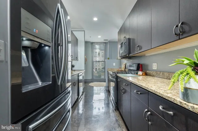 a kitchen with stainless steel appliances granite countertop a refrigerator and a sink