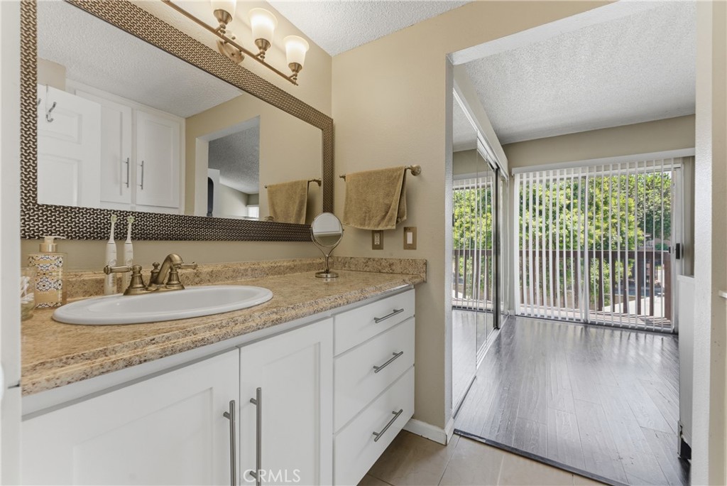 700 West Almond Street Compton, CA 90220 - Photo 41 of 68 a en suite bathroom with a granite countertop sink and a mirror