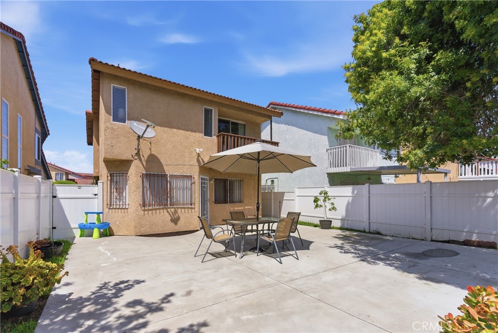700 West Almond Street Compton, CA 90220 - Photo 59 of 68 a patio with a table and chairs under an umbrella