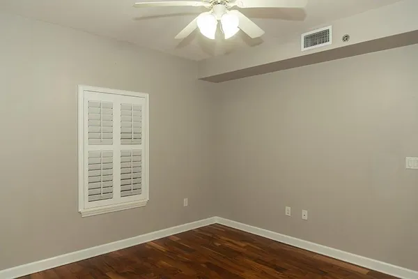 an empty room with wooden floor and closet area