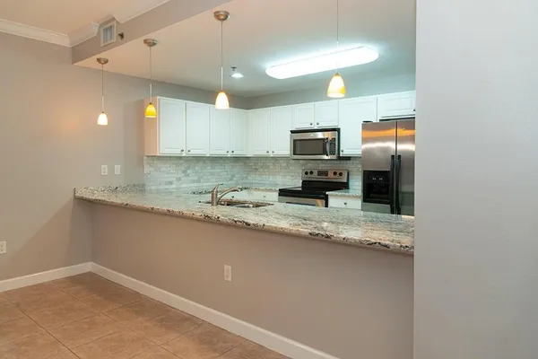 a kitchen with stainless steel appliances granite countertop a sink a stove and a refrigerator