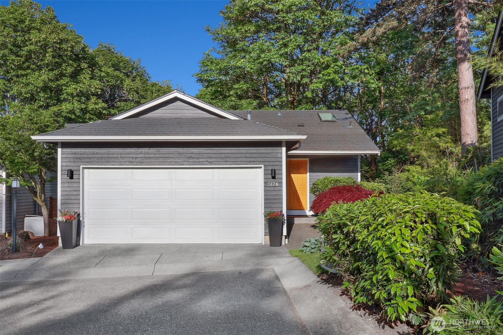 5126 South Garden Loop Road, Unit 11 Seattle, WA 98118 - Photo 2 of 36 a front view of a house with a yard and garage
