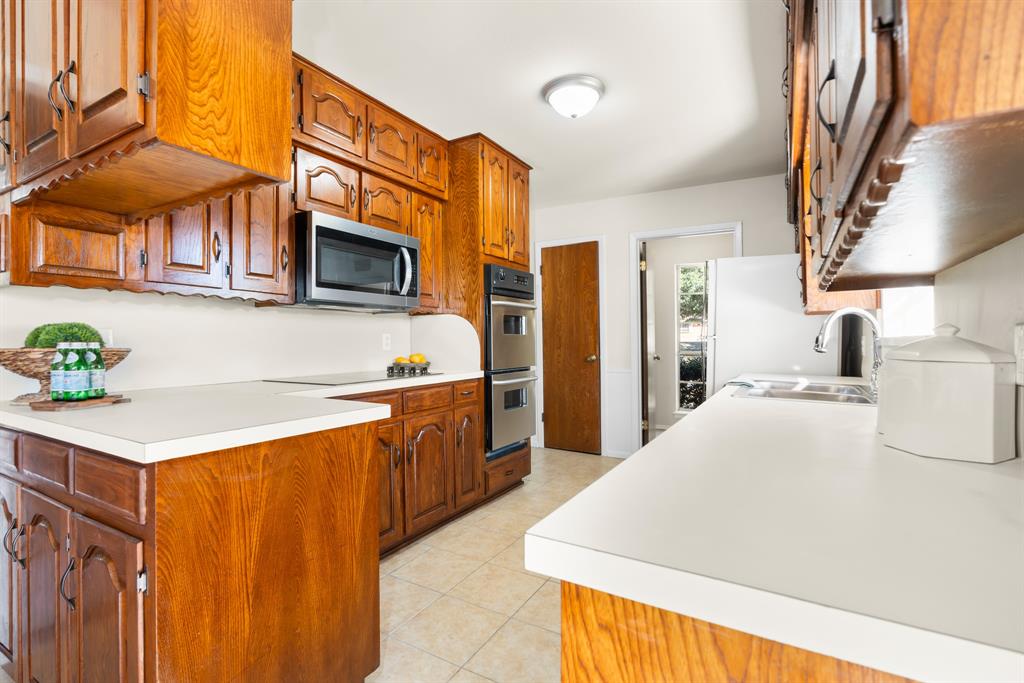 616 South Files Street Itasca, TX 76055 - Photo 12 of 37 a kitchen with stainless steel appliances a stove refrigerator sink and microwave