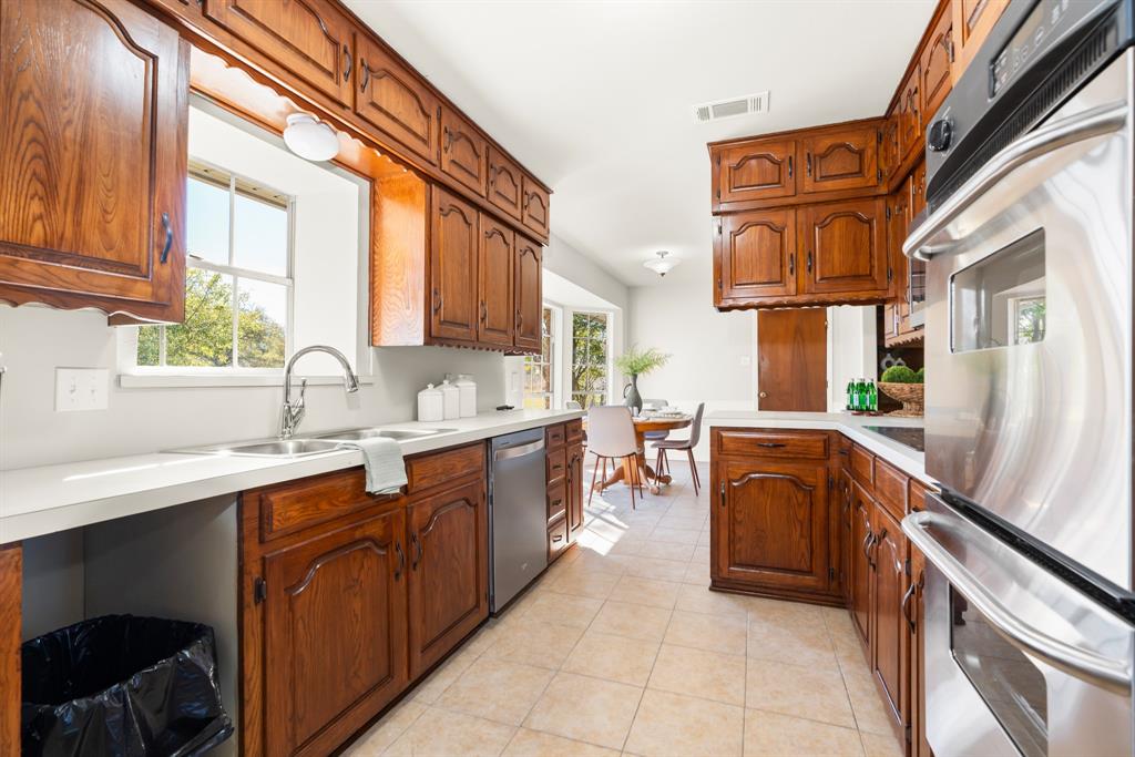 616 South Files Street Itasca, TX 76055 - Photo 13 of 37 a kitchen with stainless steel appliances granite countertop a sink and cabinets