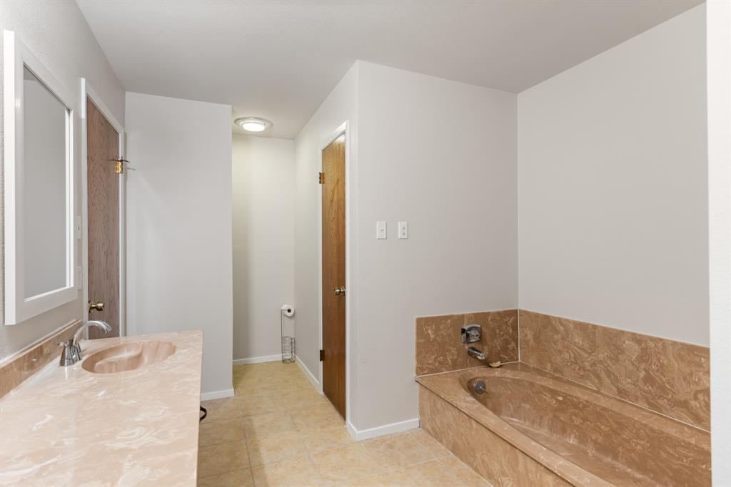 616 South Files Street Itasca, TX 76055 - Photo 18 of 37 a bathroom with a tub shower and sink