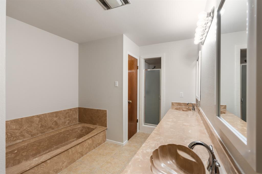 616 South Files Street Itasca, TX 76055 - Photo 19 of 37 a en suite bathroom with a tub and shower