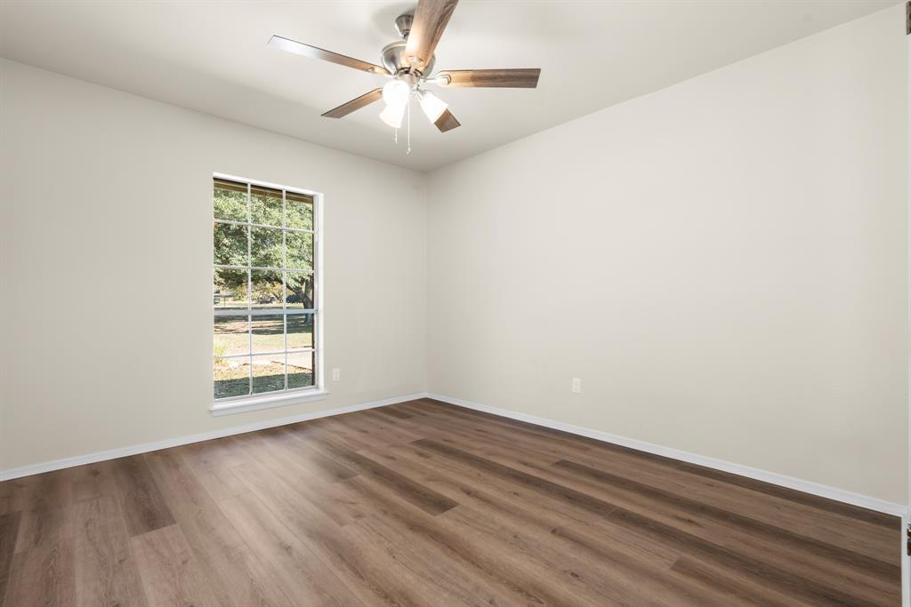 616 South Files Street Itasca, TX 76055 - Photo 22 of 37 wooden floor in an empty room with a window