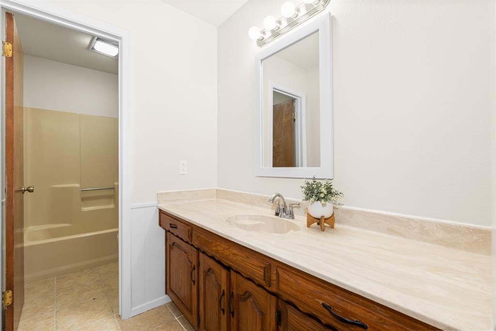 616 South Files Street Itasca, TX 76055 - Photo 24 of 37 a bathroom with a sink and a mirror