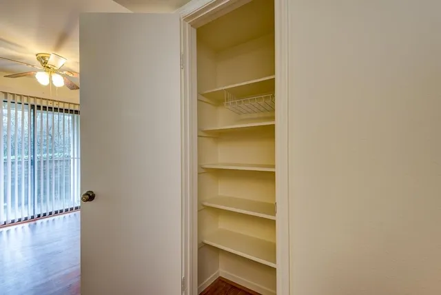 a view of walk in closet with empty racks