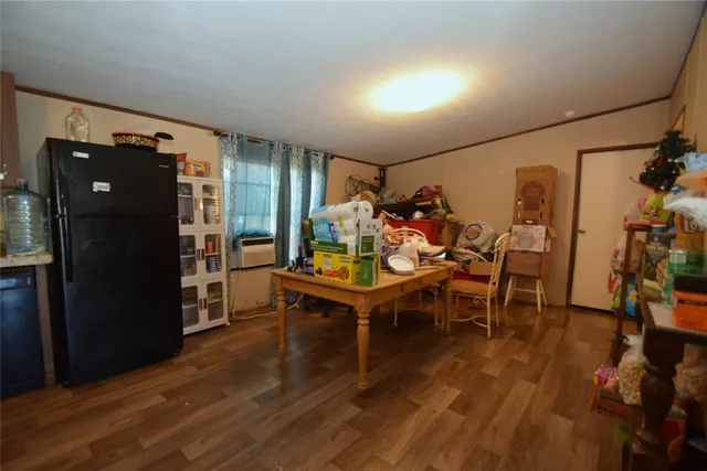 a room with stainless steel appliances kitchen island granite countertop a sink dishwasher stove and wooden floor