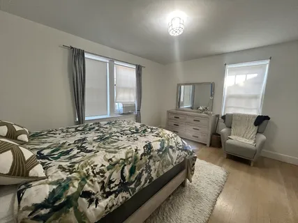 a bedroom with a bed and a view of living room