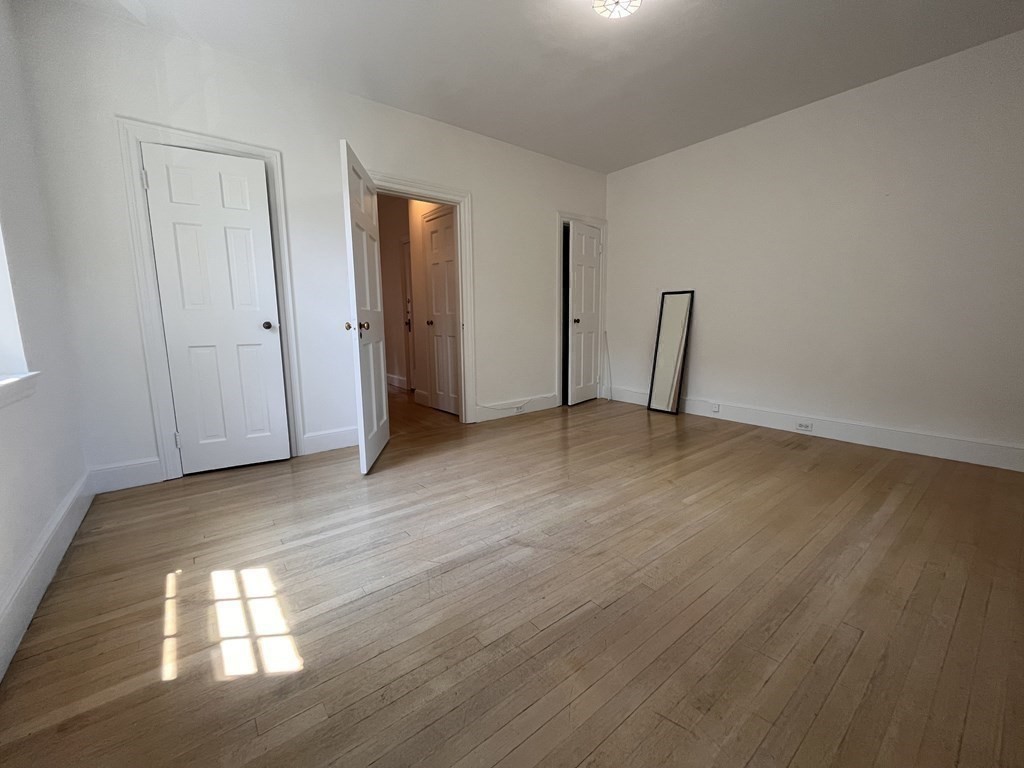 31 Park Street, Unit 6 Brookline, MA 02446 - Photo 12 of 13 a view of an empty room with wooden floor and window