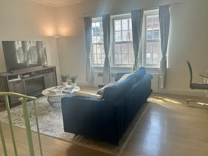 a living room with furniture and large windows