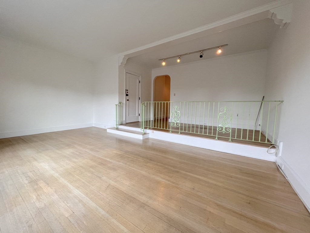 31 Park Street, Unit 6 Brookline, MA 02446 - Photo 3 of 13 an empty room with wooden floor and windows