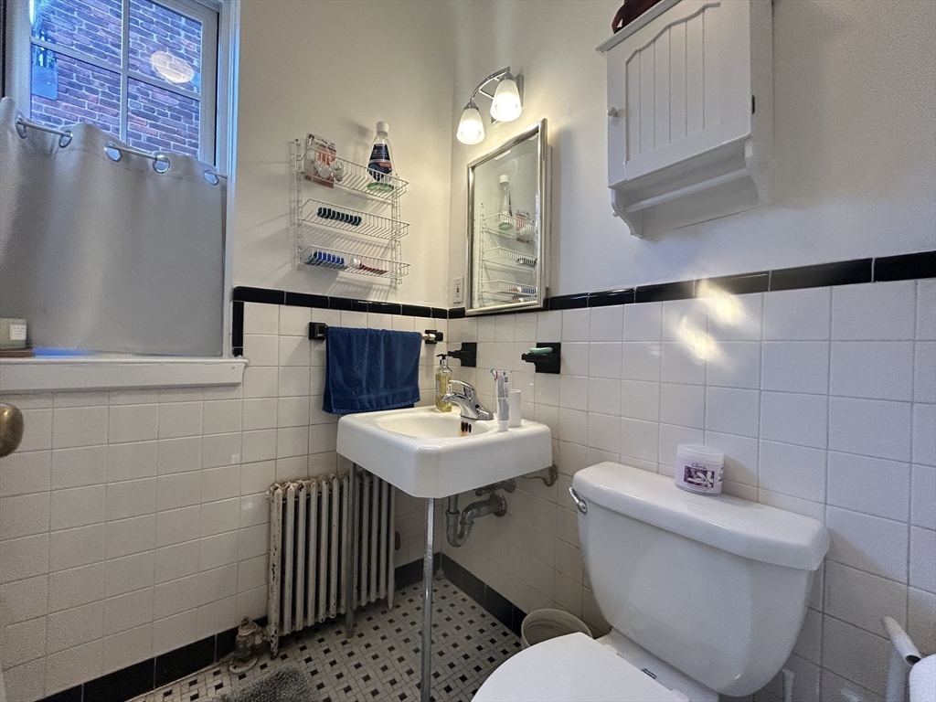 31 Park Street, Unit 6 Brookline, MA 02446 - Photo 8 of 13 a bathroom with a sink toilet and a mirror