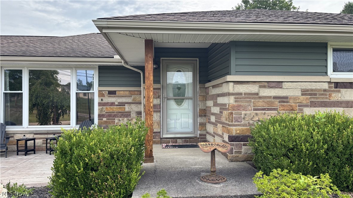 11784 Chamberlain Road Mantua, OH 44255 - Photo 37 of 50 Stone veneer facade with coordinated siding and a covered entry