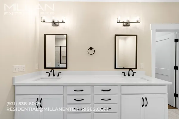a bathroom with double vanity sinks and a mirror