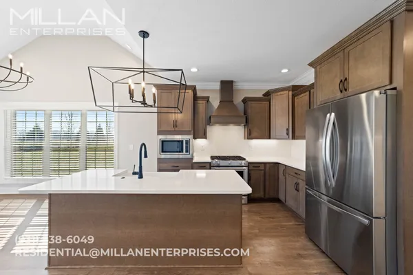 a kitchen with stainless steel appliances granite countertop a refrigerator a sink and a stove
