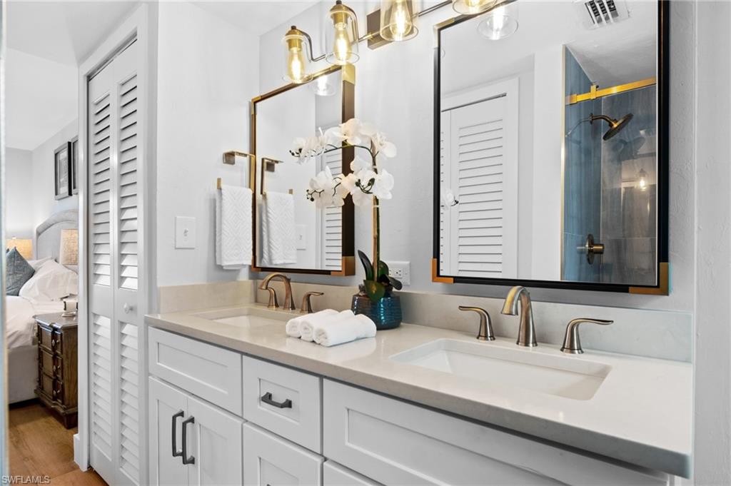 1275 7th Avenue North, Unit 201 Naples, FL 34102 - Photo 23 of 39 Full bathroom featuring a closet, double vanity, ensuite bathroom, wood finished floors, and a shower