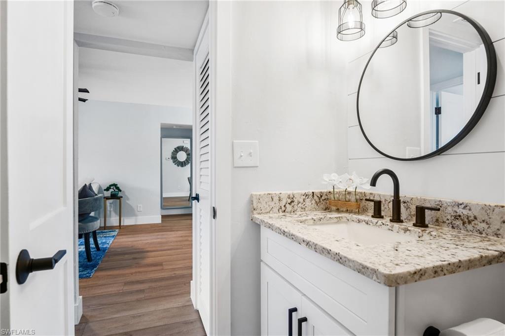 1275 7th Avenue North, Unit 201 Naples, FL 34102 - Photo 27 of 39 Bathroom with wood finished floors and vanity