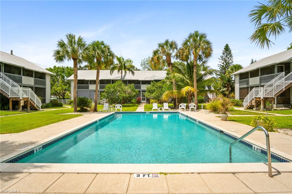 1275 7th Avenue North, Unit 201 Naples, FL 34102 - Photo 36 of 39 Community pool featuring stairway, a lawn, and a sunroom