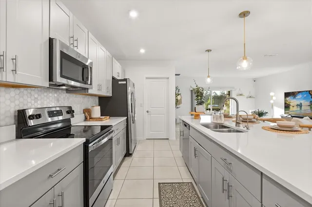 a kitchen with stainless steel appliances granite countertop a sink a stove and a refrigerator