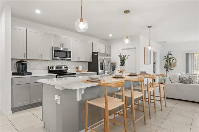 a kitchen with kitchen island white cabinets and stainless steel appliances