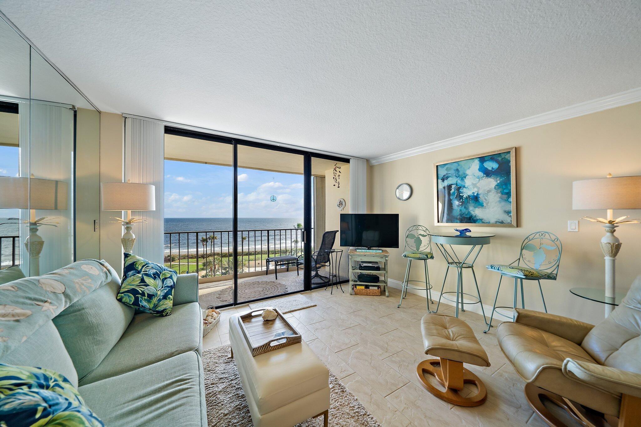 100 Ocean Trail Way, Unit 609 Jupiter, FL 33477 - Photo 6 of 66 a living room with furniture a flat screen tv and a large window