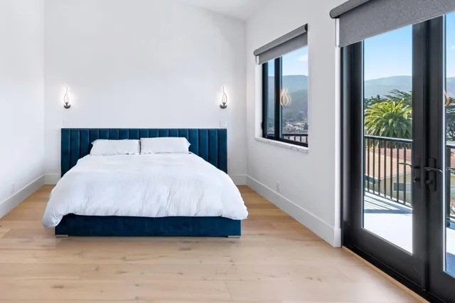 a large bed sitting in a bedroom next to a window