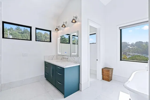 a bathroom with a granite countertop sink a mirror a vanity and window