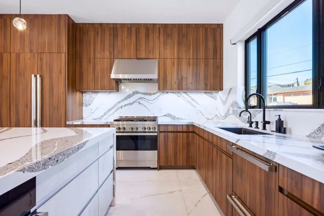 a kitchen with stainless steel appliances granite countertop a sink stove and cabinets