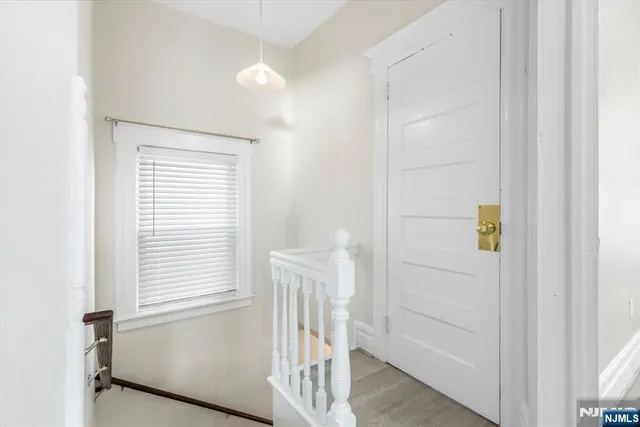 a view of a hallway with a window and wooden floor