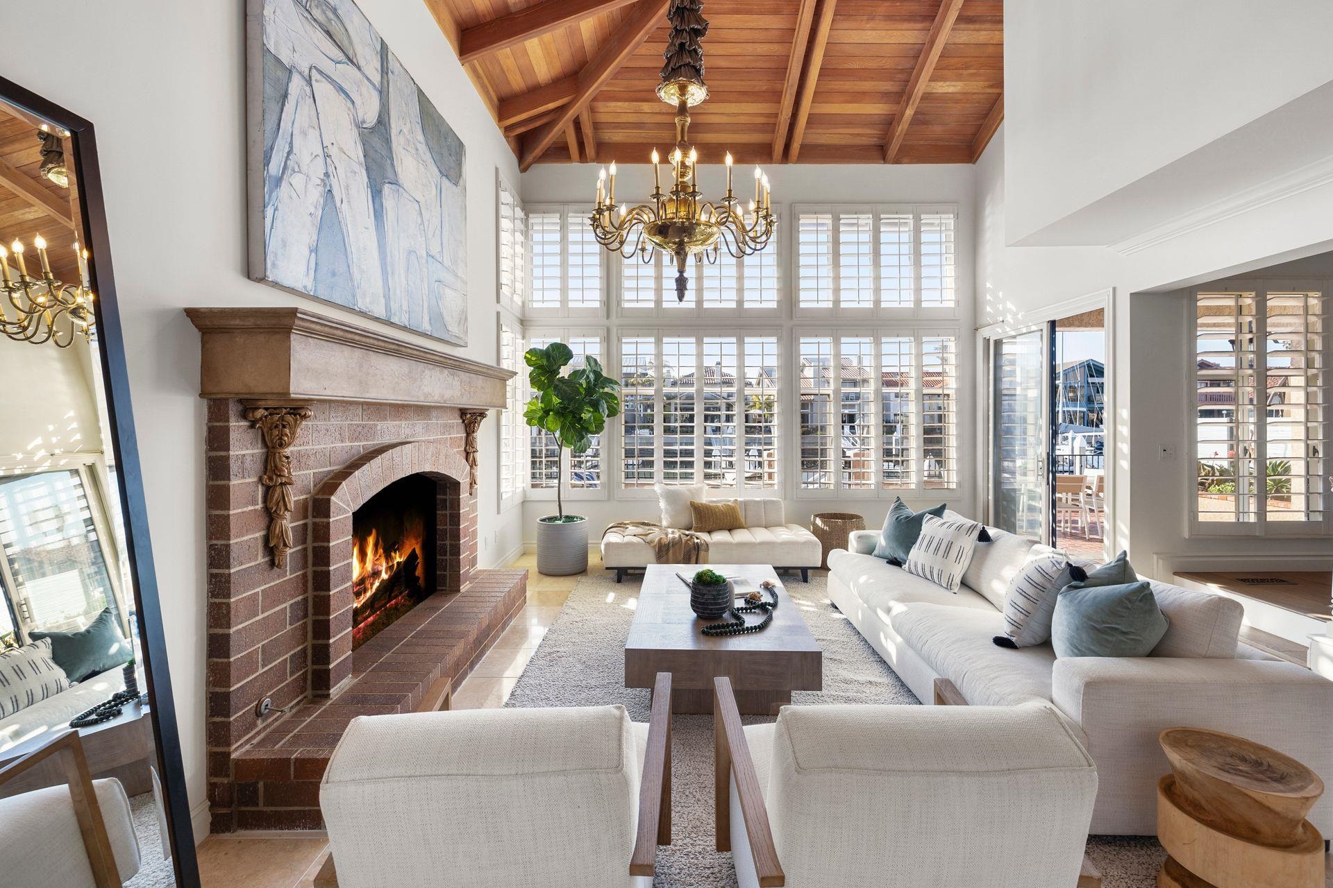 a living room with furniture a chandelier and a fireplace