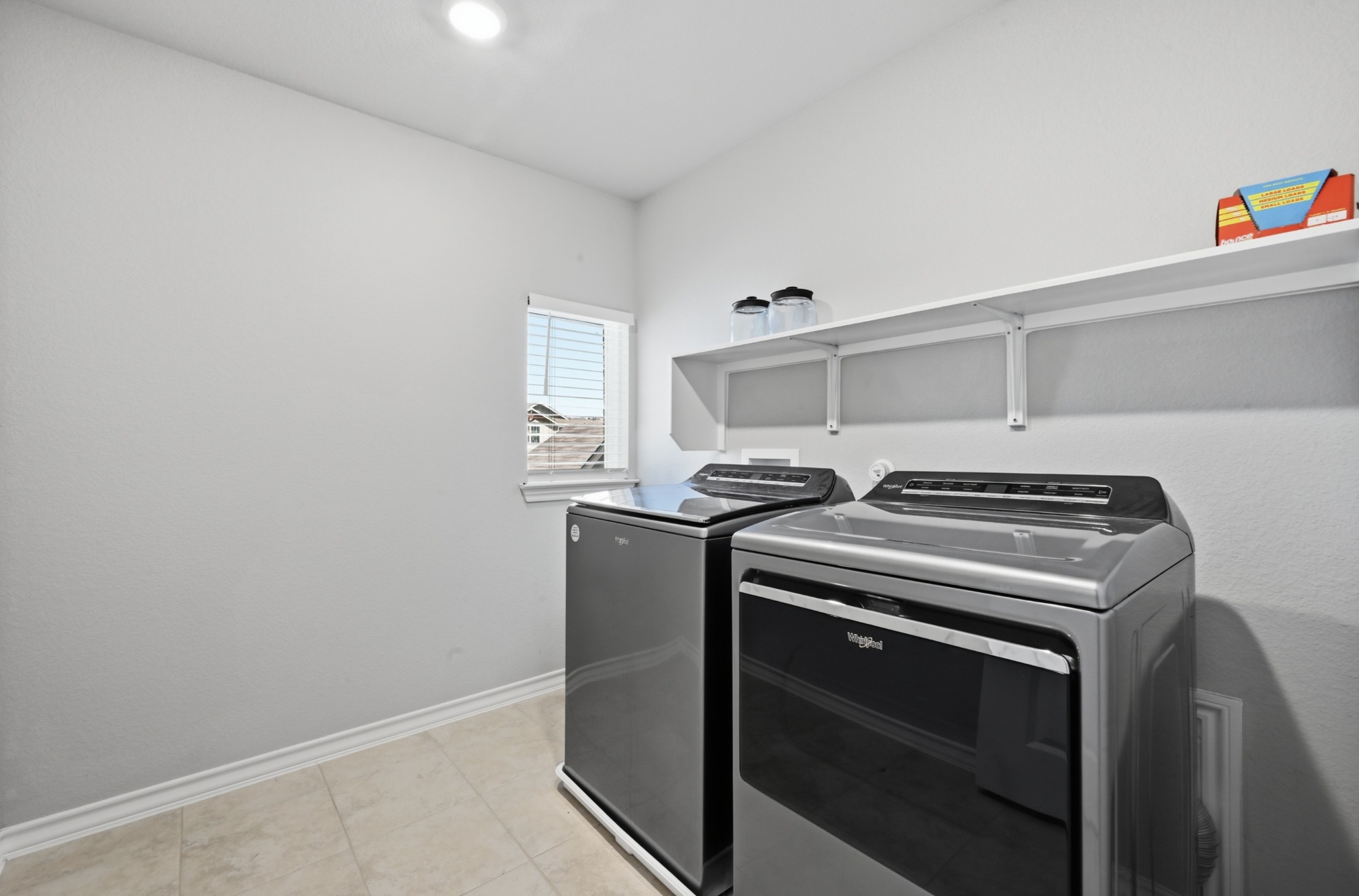 488 Pepperbark Loop Buda, TX 78610 - Photo 26 of 31 A well-appointed laundry room with modern appliances and practical shelving awaits.