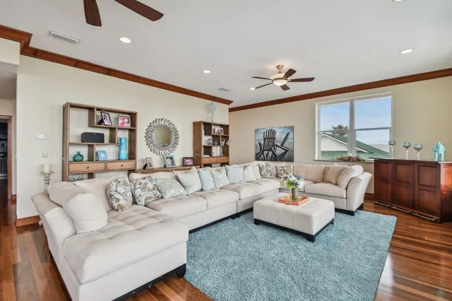 a dining room with wooden floor a chandelier a glass table and chairs
