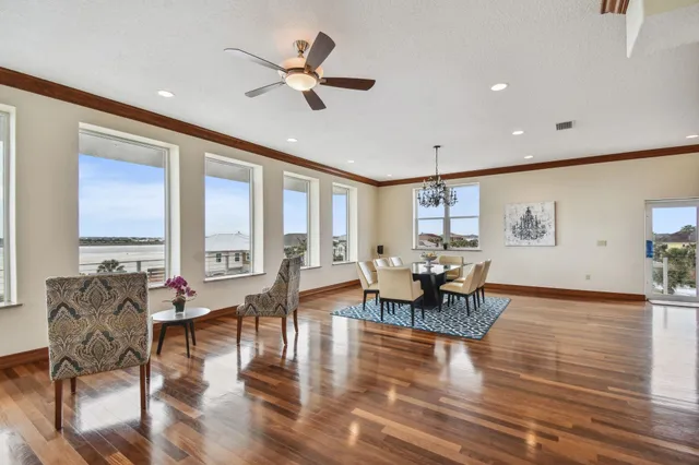 a dining room with wooden floor a chandelier a wooden table and chairs