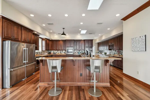 a kitchen with stainless steel appliances granite countertop a sink stove and cabinets