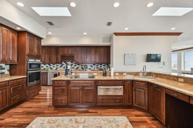 a living room with furniture a flat screen tv and kitchen view