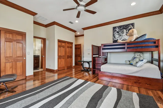 a very nice looking room with wooden floor and a ceiling fan