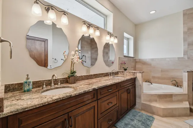 a en suite bathroom with a granite countertop sink and a mirror
