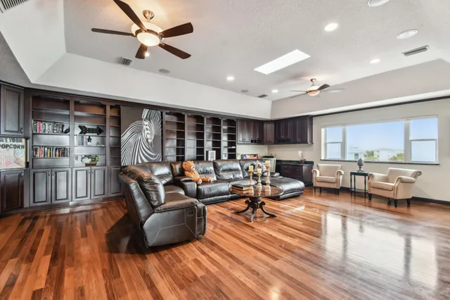 a living room with furniture kitchen view and a large window
